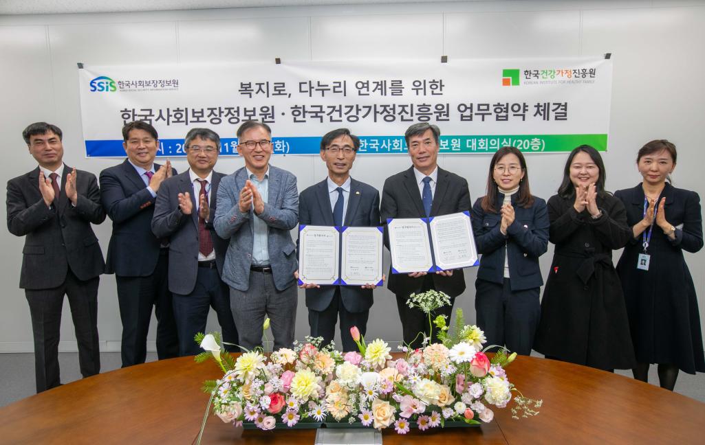 복지로, 다누리 연계를 위한 한국사회보장정보원 · 한국건강가정진흥원 업무협약 체결서를 들고 찍은 단체 사진